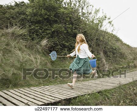 Stock Photo - Girl running along decking. Fotosearch