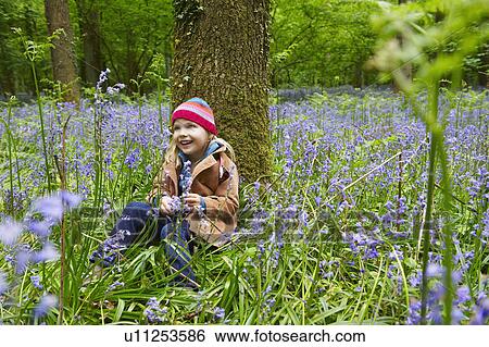 Stock Photograph - Girl sitting against a tree. Fotosearch