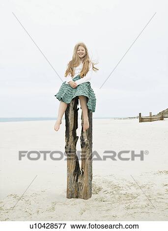 Girl sitting on top of post smiling View Large Photo Image Stock Photo - Girl sitting on top of post smiling. Fotosearch