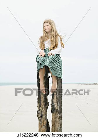 Girl sitting on top post View Large Photo Image Stock Photo - Girl sitting on top post. Fotosearch