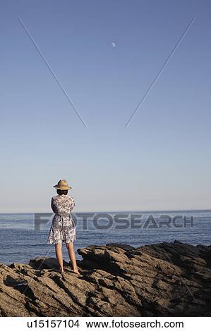 Girl standing on rocks by the sea View Large Photo Image Picture - Girl standing on rocks by the sea. Fotosearch