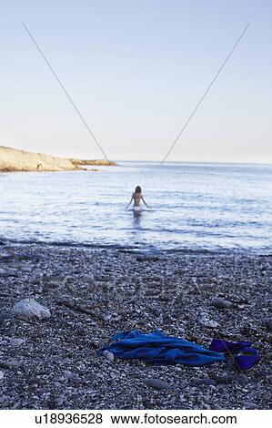 Stock Photo - Girl wading into the ocean. Fotosearch