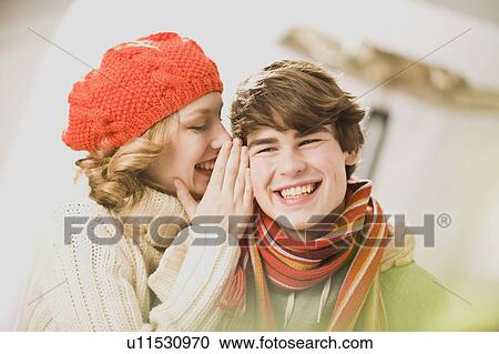girl whispers boy something into his ear View Large Photo Image Stock Image - girl whispers boy something into his ear. Fotosearch