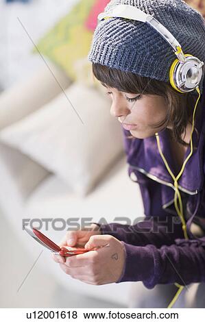 Girl with headphones and cell-phone View Large Photo Image Stock Photo - Girl with headphones and cell-phone. Fotosearch