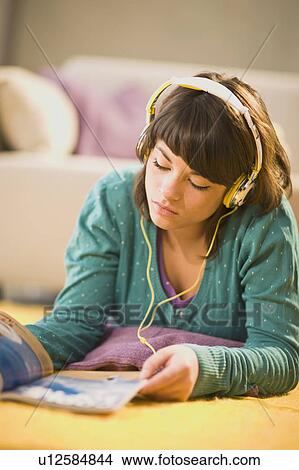Picture - Girl with headphones and magazine. Fotosearch