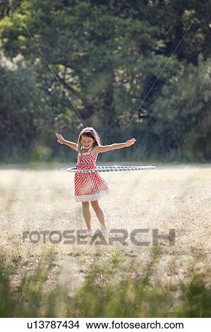 Girl with hula hoop in country field View Large Photo Image Picture - Girl with hula hoop in country field. Fotosearch