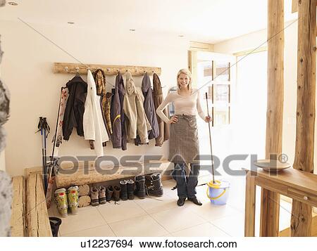 Picture - Girl with mop and bucket in ski chalet. Fotosearch