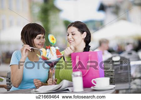 Picture - girlfriends enjoying icecream. Fotosearch