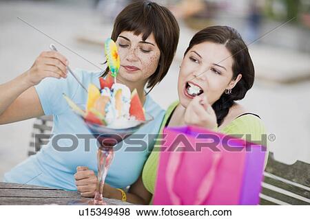 Stock Photo - girlfriends enjoying icecream. Fotosearch