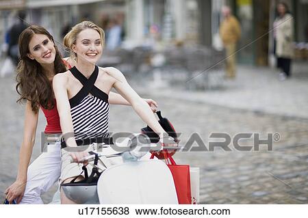 Stock Photo - girlfriends on a motor scooter. Fotosearch