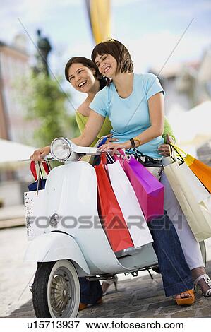 girlfriends with motor scooter laughing View Large Photo Image Stock Photo - girlfriends with motor scooter laughing. Fotosearch