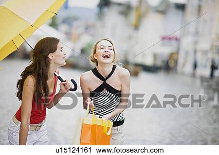 Stock Image - girls having fun in the rain. Fotosearch