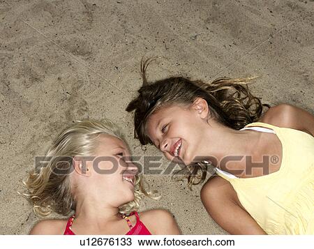 Girls lying at the beach View Large Photo Image Stock Image - Girls lying at the beach. Fotosearch