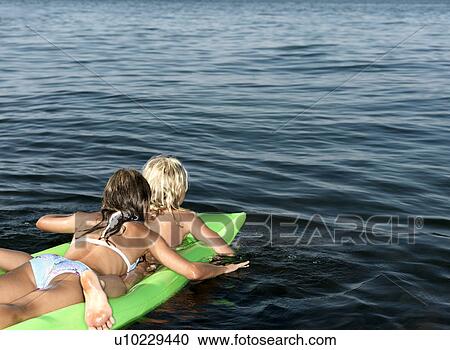 Stock Image - Girls on inflatable mattress. Fotosearch