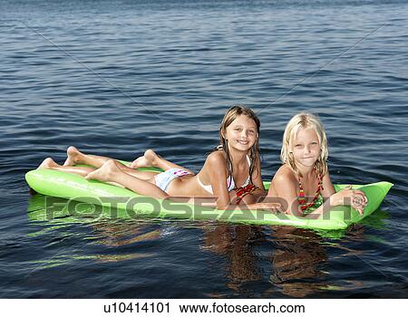 Stock Image - Girls on inflatable mattress. Fotosearch