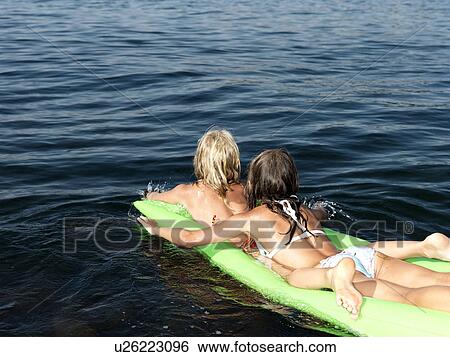 Stock Photograph - Girls on inflatable mattress. Fotosearch