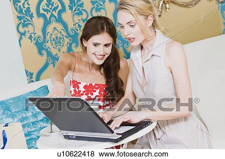 Stock Photo - girls working on a laptop in a cafe. Fotosearch