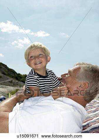 Stock Image - Grandfather and boy hugging. Fotosearch