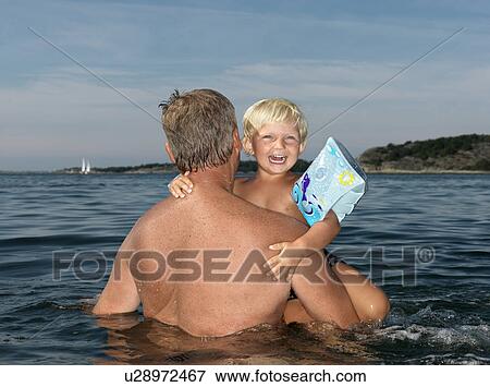 Grandfather and boy playing in water View Large Photo Image Stock Photo - Grandfather and boy playing in water. Fotosearch