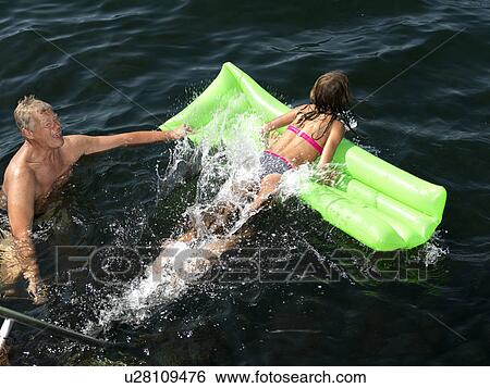 Grandfather and girl playing in water View Large Photo Image Stock Photograph - Grandfather and girl playing in water. Fotosearch