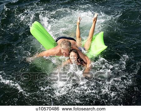 Grandfather playing with girl in water View Large Photo Image Stock Photograph - Grandfather playing with girl in water. Fotosearch