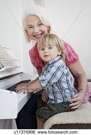 Granny and grandson sit at a piano View Large Photo Image Stock Photograph - Granny and grandson sit at a piano. Fotosearch