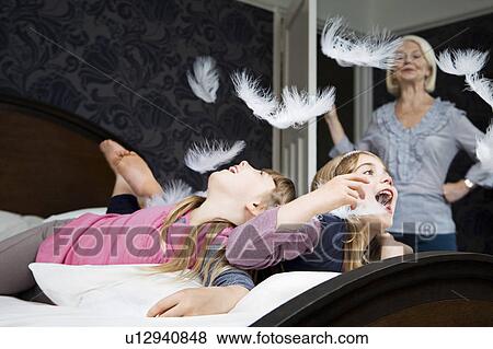Stock Photo - Granny disapproves girls pillow fighting. Fotosearch