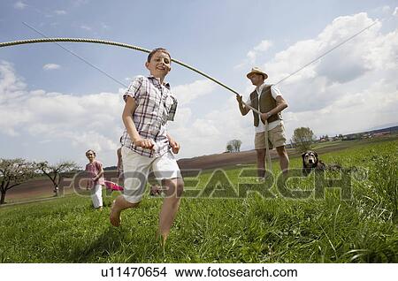 Happy family jump roping in countryside View Large Photo Image Picture - Happy family jump roping in countryside. Fotosearch