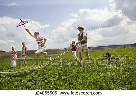Stock Photography - Happy people jump roping in countryside. Fotosearch