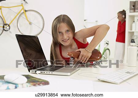 Picture - joung girl testing saddle. Fotosearch