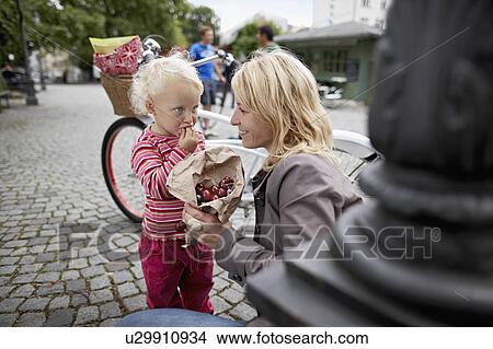 Little girl and mother eating cherries View Large Photo Image Picture - Little girl and mother eating cherries. Fotosearch