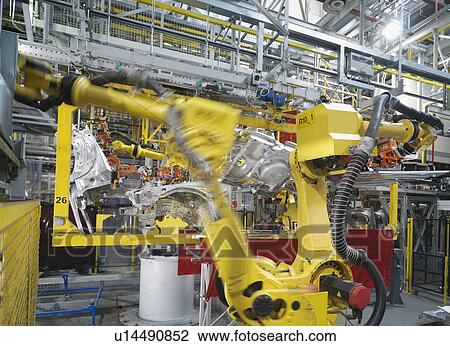 Stock Image - Machine Assembling Car In Plant. Fotosearch