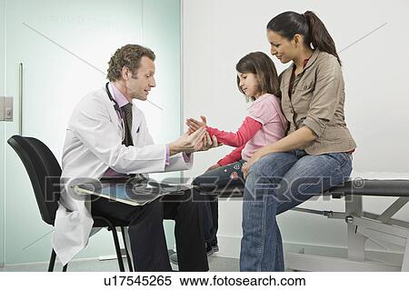 Stock Photography - Male doctor checks a patients hand. Fotosearch