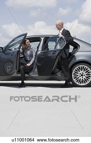 Picture - man and woman getting out of car. Fotosearch