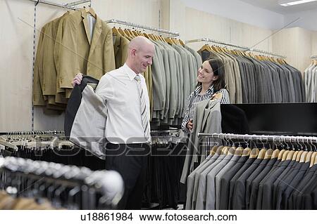 Picture - man and woman in clothing store. Fotosearch