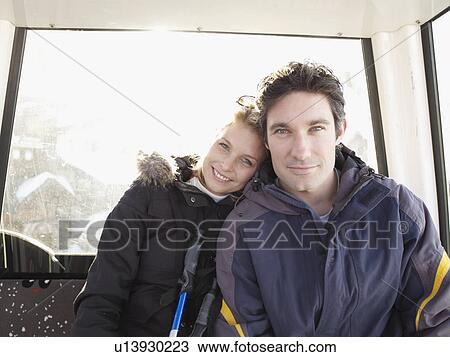 Stock Image - man and woman in ski lift. Fotosearch
