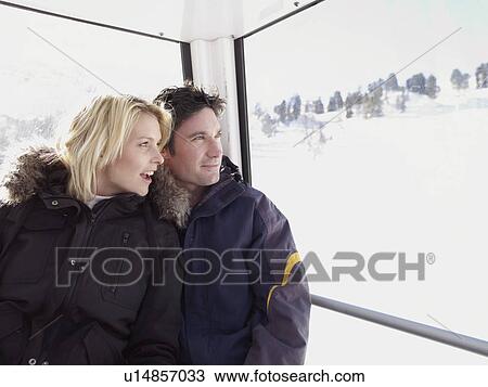 man and woman looking out from ski lift View Large Photo Image Stock Image - man and woman looking out from ski lift. Fotosearch