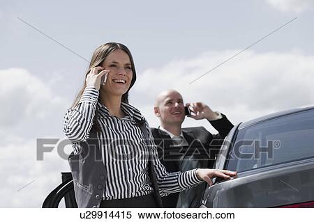 man and woman near car on the phone View Large Photo Image Stock Photography - man and woman near car on the phone. Fotosearch