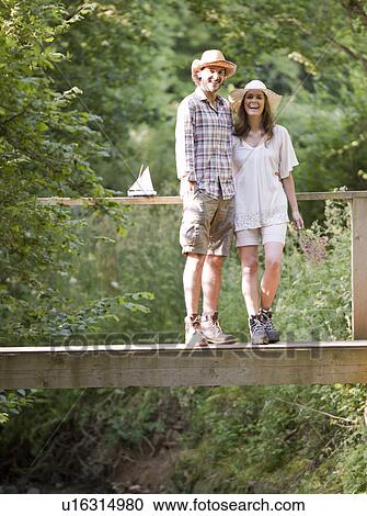 Stock Image - Man and woman on country bridge. Fotosearch