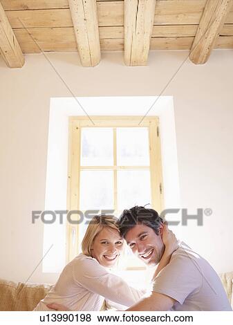 Stock Photo - man and woman on sofa in living room. Fotosearch