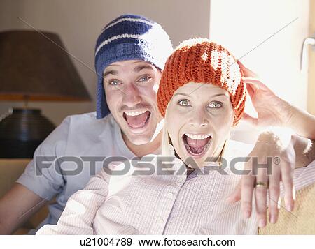 Stock Photo - man and woman on sofa in living room. Fotosearch