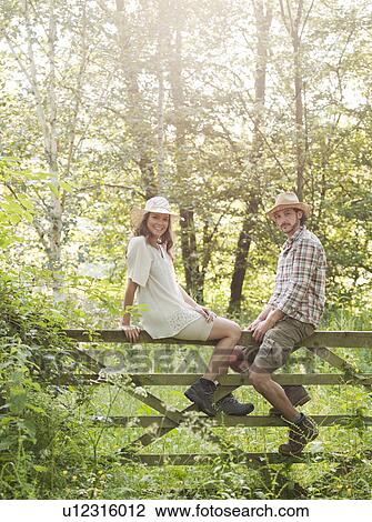 Man and woman sitting on country gate View Large Photo Image Stock Image - Man and woman sitting on country gate. Fotosearch