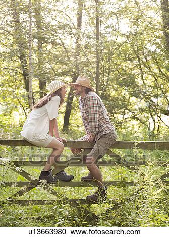 Man and woman sitting on country gate View Large Photo Image Stock Image - Man and woman sitting on country gate. Fotosearch