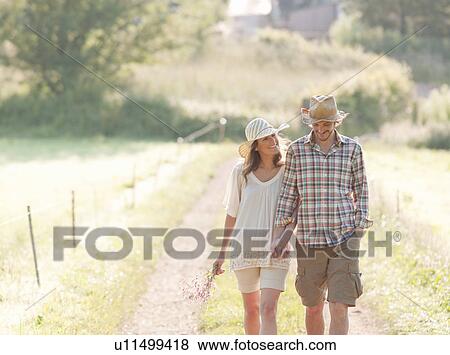 Stock Photo - Man and woman walking down lane. Fotosearch