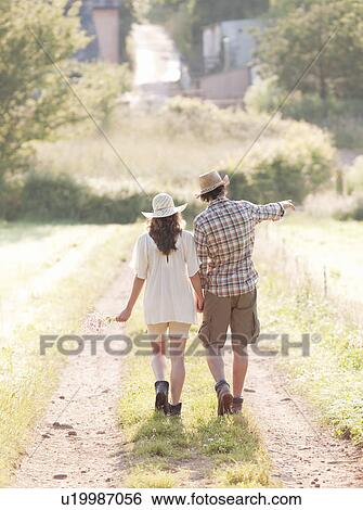 Stock Photograph - Man and woman walking down lane. Fotosearch