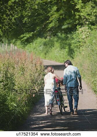 Picture - Man and woman walking up country lane. Fotosearch