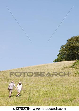 Picture - Man and woman walking up hill. Fotosearch