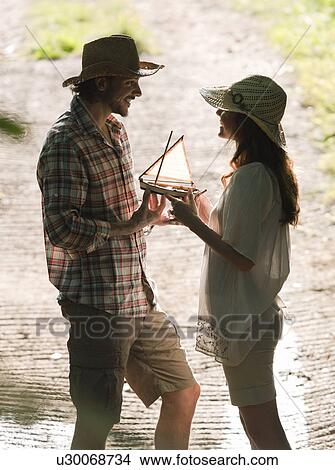Picture - Man and woman with model boat in sun. Fotosearch