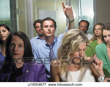Stock Photo - Man asking a question at a conference. Fotosearch