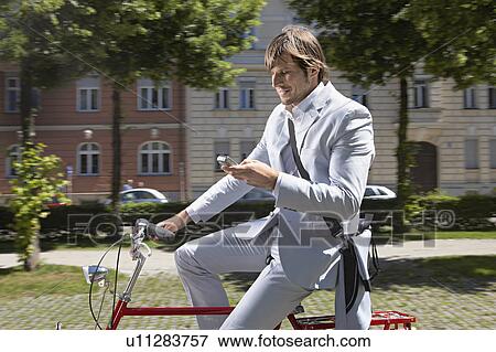 Man bicycling, talking on the phone View Large Photo Image Stock Photo - Man bicycling, talking on the phone. Fotosearch